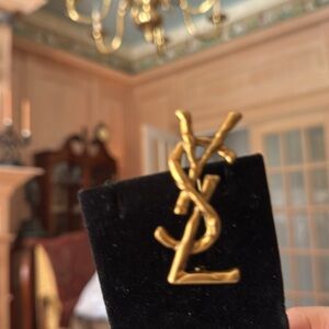Yves Saint Laurent antique Gold tone YSL Monogram Pin on Black Background